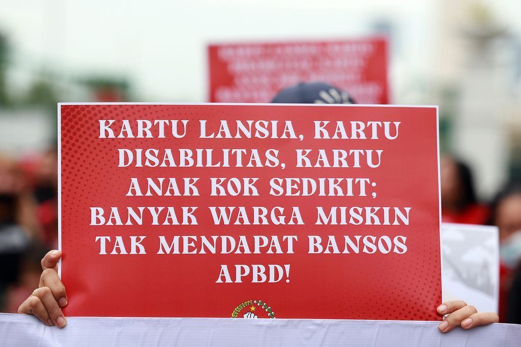 Poster aksi yang dibawa salah seorang warga ketika menggelar aksi di depan Mounemen Nasional (Monas) dan berjalan ke Balai Kota Jakarta, Rabu (26/10/2022). 