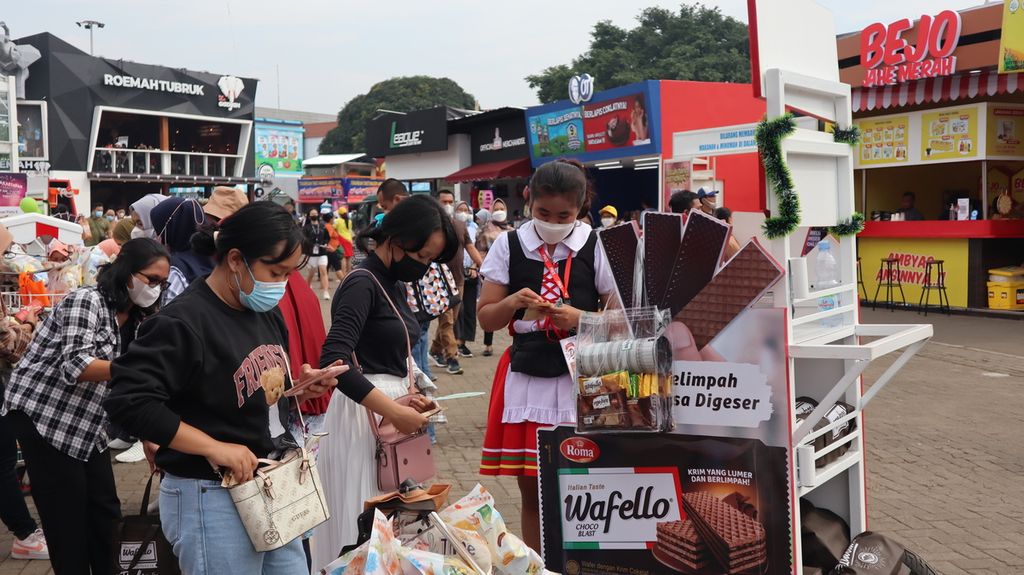 Pengunjung Jakarta Fair Kemayoran, Jakarta Pusat, Sabtu (18/6/2022), tengah membeli produk makanan yang ditawarkan seorang <i>sales promotion girl</i> (SPG).
