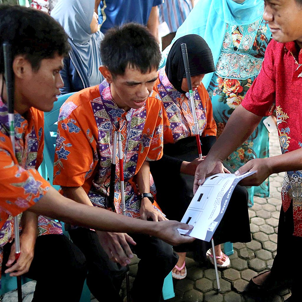 Penyandang disabilitas mendapatkan pengarahan dari anggota KPPS sebelum menggunakan hak pilih mereka dalam Pilkada Gubernur dan Wakil Gubernur DKI Jakarta  2017 di TPS 07, Kelurahan Cawang, Jakarta, Rabu (15/2).