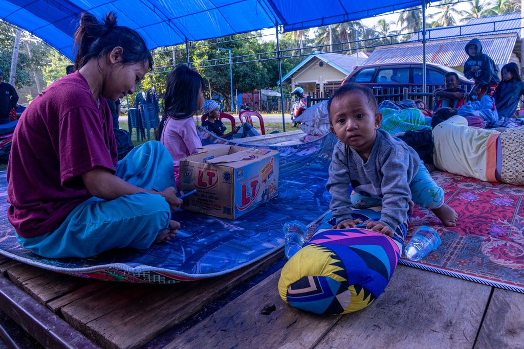 Anak-anak bermain di salah satu lokasi pengungsian darurat di Desa Telaga Biru, Konawe, Sulawesi Tenggara, Minggu (27/3/2022) pagi. Gempa dengan kekuatan M 5,2 pada Sabtu (26/3/2022) malam membuat warga pesisir mengungsi dan sejumlah bangunan rusak.