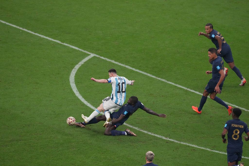 Pemain Argentina Lionel Messi (kiri) dikepung oleh para pemain Perancis pada final Piala Dunia 2022 di Stadion Lusail, Qatar, Senin (19/12/2022) dini hari WIB. Argentina menjuarai Piala Dunia 2022 setelah mengalahkan Perancis lewat adu tendangan penalti dengan skor 4-2 (3-3). 
