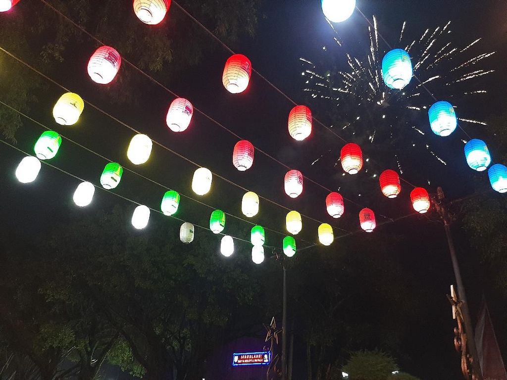Pendar-pendar cahaya dari kembang api tampak di sela-sela lampion yang dipasang di sekitar Alun-alun Magelang, Kota Magelang, Minggu (1/5/2022).