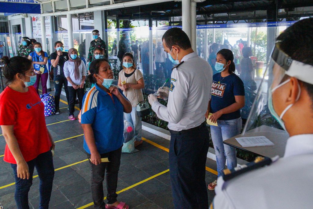 Petugas Kantor Imigrasi Kelas I Khusus Batam memeriksa kelengkapan dokumen para pekerja migran Indonesia di Pelabuhan Internasional Batam Centre, Kota Batam, Kepulauan Riau, Kamis (21/5/2020).