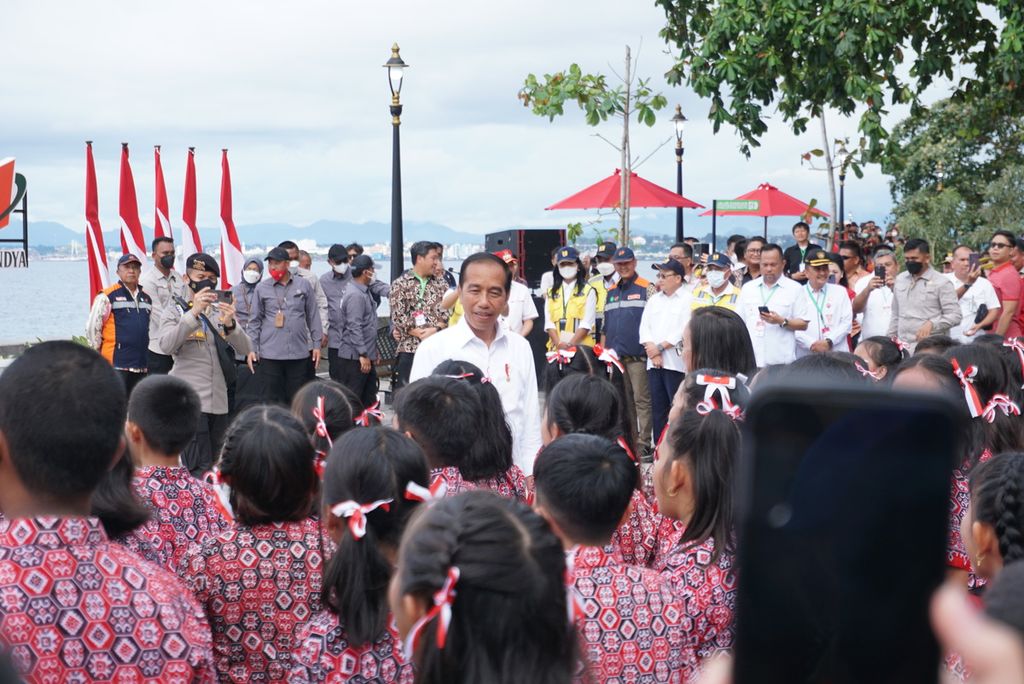 Presiden Joko Widodo menyapa anak-anak SD ketika meresmikan anjungan pantai Malalayang Beach Walk, Jumat (20/1/2023), di Manado, Sulawesi Utara. Proyek tersebut dibangun dengan anggaran APBN senilai Rp 65,48 miliar selama 2020-2022.