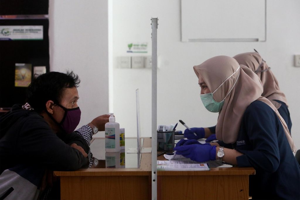 Warga mengurus administrasi di kantor BPJS Kesehatan Cabang Jakarta Selatan di Pancoran, Kamis (14/5/2020). Di tengah pandemi Covid-19, pemerintah memutuskan untuk menaikkan iuran BPJS Kesehatan. Padahal, sebelumnya dalam putusan pada 31 Maret 2020, Mahkamah Agung sudah membatalkan kenaikan iuran yang dibuat pemerintah pada 2019.