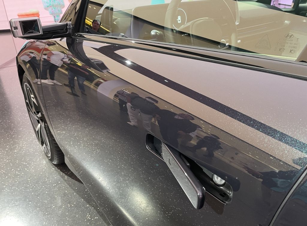 Seperti Hyundai Ioniq 5, model Ioniq 6 juga menggunakan tuas pintu bersistem tanam (<i>flush</i>) yang rata dengan bodi. Khusus pada unit contoh yang dipasarkan di Korea Selatan ini, ”kaca spion” samping tak memakai cermin, melainkan kamera. Spesifikasi kaca spion ini menyesuaikan dengan regulasi setiap negara.
