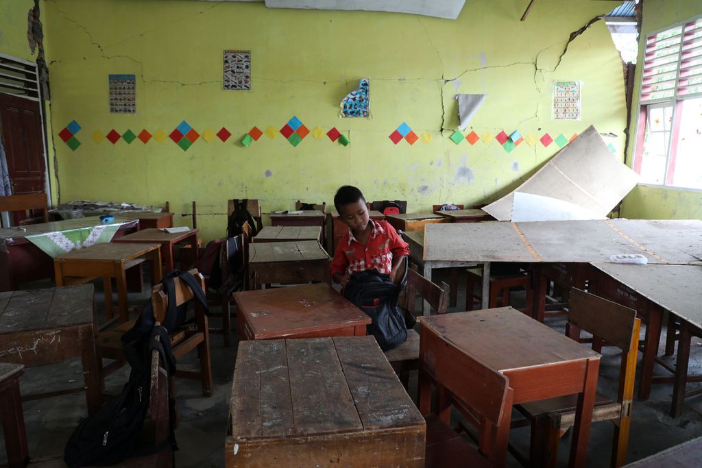 Rivaldo, siswa kelas V Masdrasah Ibtidaiyah Al Wahid mengambil tas sekolahnya yang tertinggal di sekolah di Nagari Kajai, Kecamatan Talamau, Kabupaten Pasaman Barat, Sumatera Barat, Senin (28/2/2022). 
