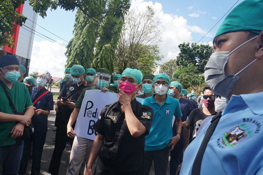 Sekitar 50 dokter residen peserta program pendidikan dokter spesialis (PPDS) Universitas Sam Ratulangi, Manado, Sulawesi Utara, menggelar aksi untuk menuntut penurunan biaya operasional pendidikan (BOP), Jumat (24/7/2020). Uang kuliah yang mencapai Rp 24 juta per semester dinilai terlalu memberatkan ketika pemasukan mereka kurang semasa pandemi Covid-19.