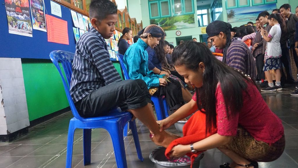 Guru membasuh kaki muridnya di SMP Pius, Cilacap, Jawa Tengah, Senin (25/11/2019). Guru dan murid saling bergantian membasuh kaki dalam peringatan Hari Guru Nasional sebagai simbol kerendahan hati dan saling menghormati.