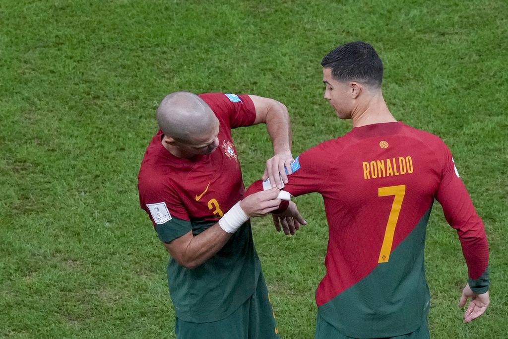 Pemain Portugal Pepe memasang tanda kapten di lengan Cristiano Ronaldo dalam laga 16 besar Piala Dunia Qatar 2022 melawan Swiss di Stadion Lusail, Rabu (7/12/2022) dini hari WIB. Portugal menang telak 6-1 tapi Ronaldo kembali gagal melesakan gol di laga itu. 