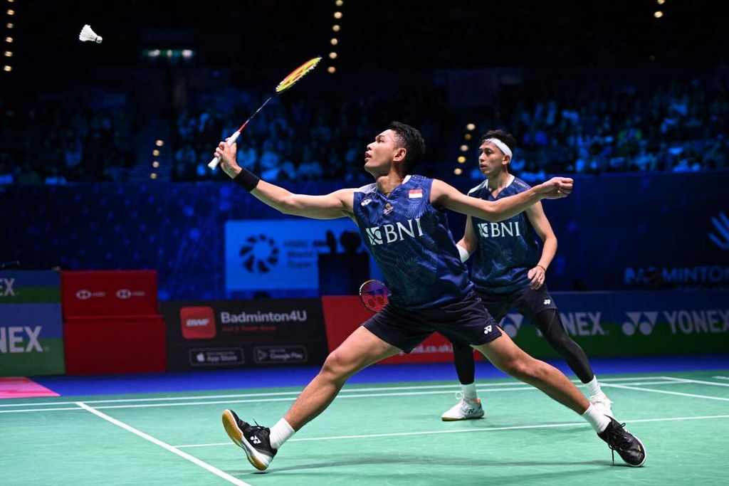 Indonesia's Fajar Alfian (L) playing with Indonesia's Muhammad Rian Ardianto (R) returns to Indonesia's Mohammad Ahsan and Indonesia's Hendra Setiawan during the Men's Doubles Final at the All England Open Badminton Championships at the Utilita Arena in Birmingham, central England, on March 19, 2023. 