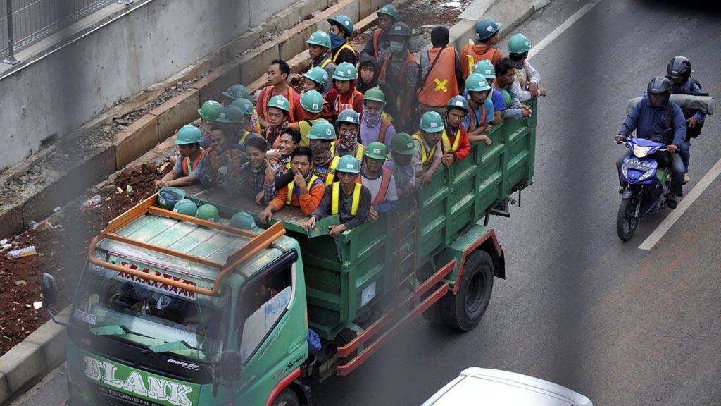 Para pekerja proyek infrastruktur naik di atas truk saat menuju lokasi kerja di Jalan TB Simatupang, Cilandak, Jakarta Selatan, Selasa (23/10/2018). Proyek infrastruktur yang dibangun pemerintah saat ini mampu menyerap lebih dari 200.000 pekerja.