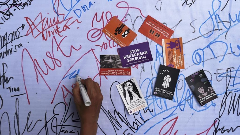 Warga membubuhkan tanda tangan saat aksi damai tolak kekerasan seksual pada perempuan, di Jalan Darmo, Surabaya, Jawa Timur, Minggu (9/12/2018). Mereka mendesak untuk segera disahkannya RUU Penghapusan Kekerasan Seksual.