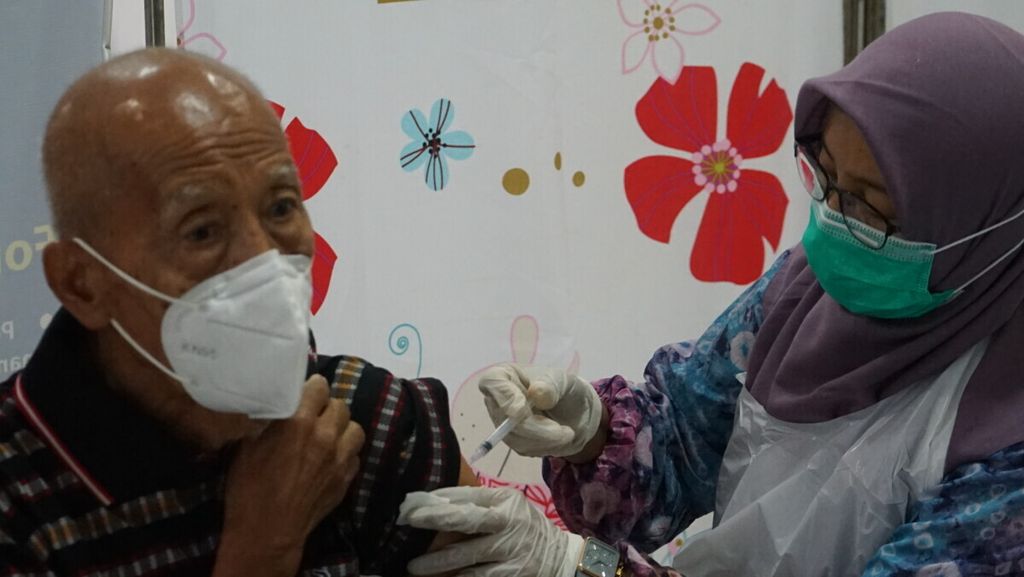 Seorang kaum lanjut usia tengah mengikuti vaksinasi dosis penguat di Puskesmas 5 Ilir Palembang, Sumatera Selatan, Kamis (13/1/2022). Vaksinasi ini penting untuk meningkatkan imunitas kaum rentan termasuk lansia. Hanya saja, cakupan vaksinasi lansia di Palembang masih rendah.