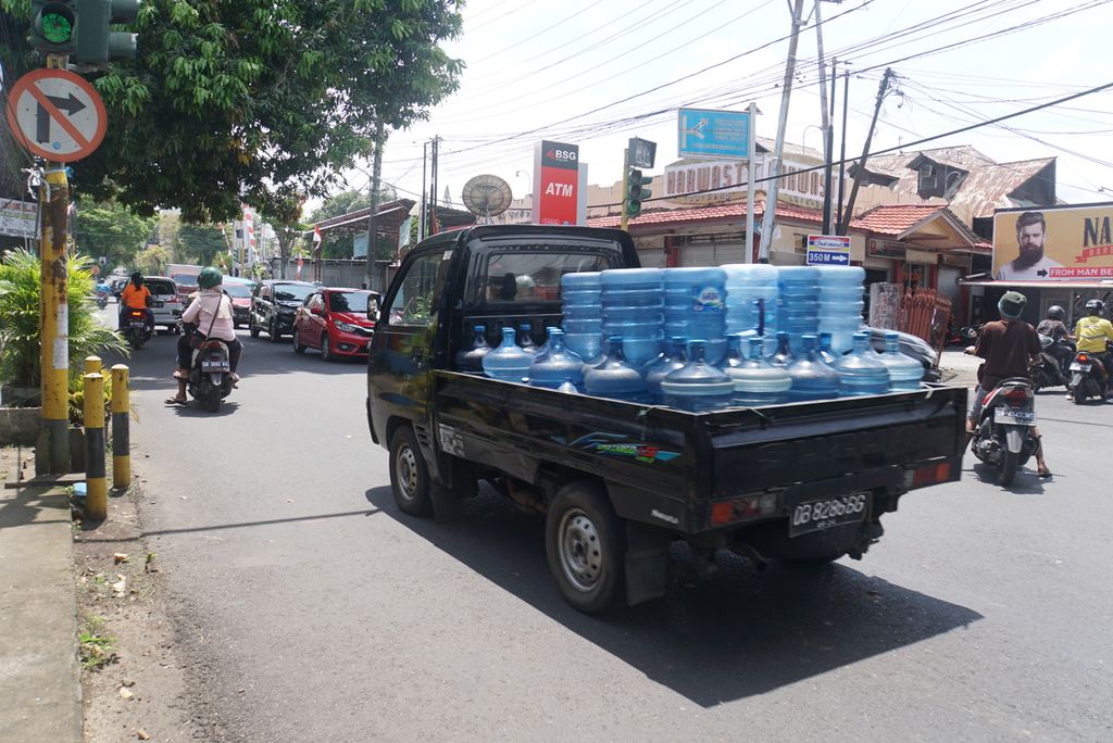 Sebuah mobil bak terbuka mengangkut puluhan galon air mineral, Jumat (16/9/2022), di Manado, Sulawesi Utara.