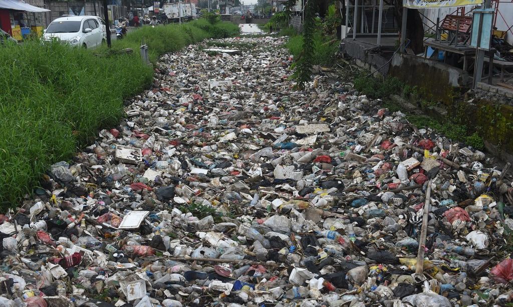 Sampah menumpuk di saluran air di Jalan Ketajen, Kabupaten Sidoarjo, Jawa Timur, Rabu (23/11/2022). Sampah tersebut dinominasi oleh sampah plastik juga polyfoam yang sulit terurai. Karena bermuara di laut, sampah yang menumpuk selain dapat menyebabkan banjir juga dapat mencemari kawasan pantai. Kompas/Bahana Patria Gupta (BAH)