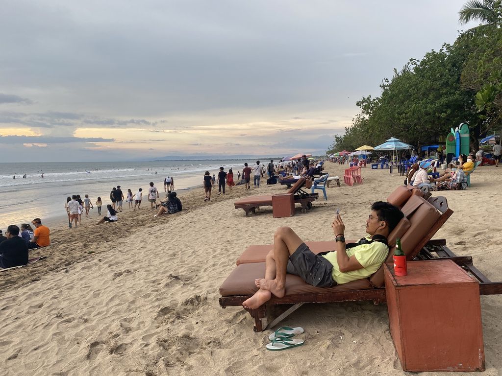 Wisata menikmati pemandangan di Pantai Kuta, Kabupaten Badung, Bali, Jumat (25/3/2022). 