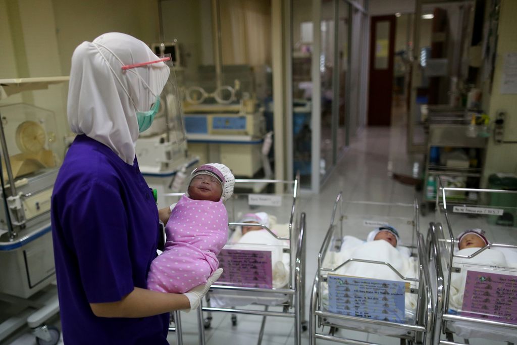 Perawat mengontrol bayi yang baru lahir di ruang bayi Rumah Sakit Ibu dan Anak Tambak, Jakarta, Senin (20/4/2020). Baik bayi maupun perawat mengenakan pelindung wajah (<i>face shield</i>). Kebijakan internal pemasangan pelindung wajah pada bayi yang baru lahir ini dilakukan untuk meminimalkan bayi terpapar virus korona baru melalui droplet.