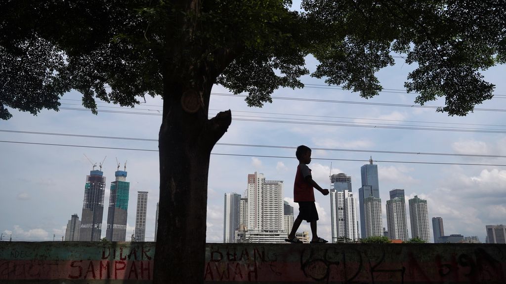 Siluet anak berlatar gedung bertingkat di kawasan Tanah Abang, Jakarta Pusat, Senin (31/10/2022). Pemerintah akan berupaya menekan belanja negara hingga akhir tahun ini. Sisa anggaran tahun 2022 akan disimpan untuk dipakai sebagai dana cadangan atau <i>cash buffer </i>pada APBN 2023 guna mengantisipasi ketidakpastian ekonomi yang diprediksi semakin tinggi tahun depan.