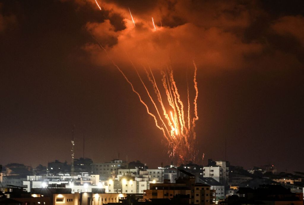 Kilauan api berkilatan di angkasa saat para pejuang Palestina menembakkan roket-roket sebagai balasan atas serangan udara Israel di Kota Gaza, Jumat (5/8/2022). 