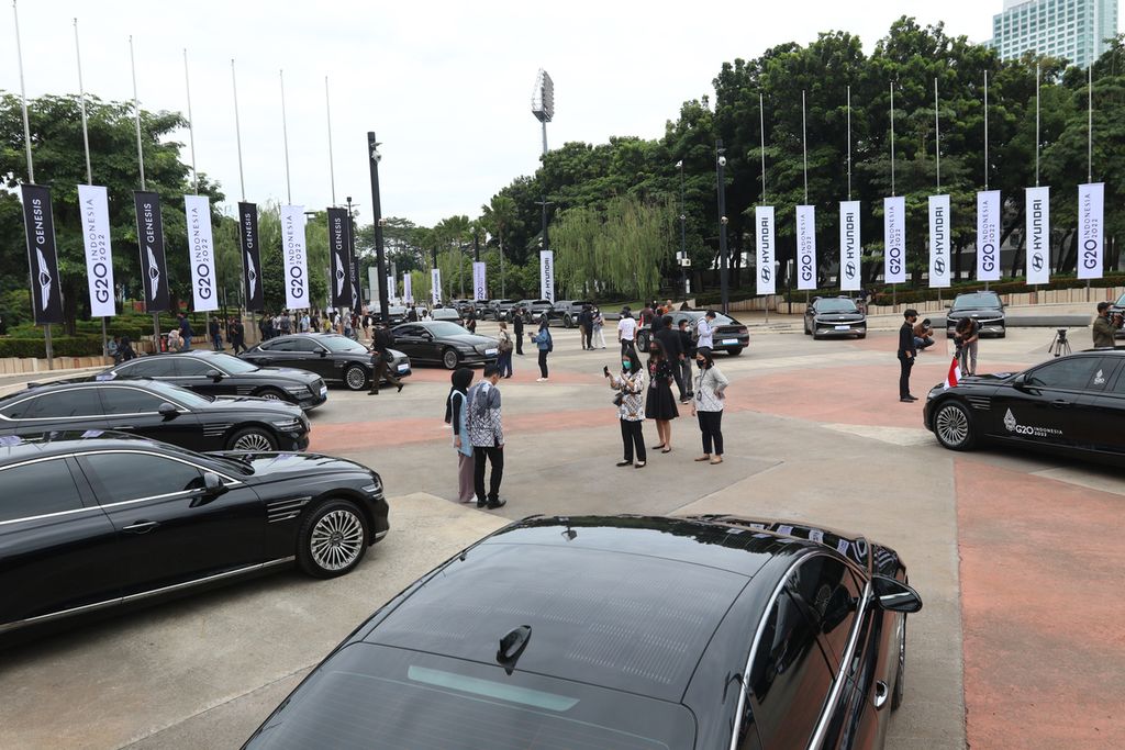 Para tamu undangan dan wartawan berfoto dengan mobil listrik Hyundai IONIQ 5 dan Genesis Electrified G80 yang diparkir di Kompleks Gelora Bung Karno, Senayan, Jakarta, Selasa (25/10/2022). 