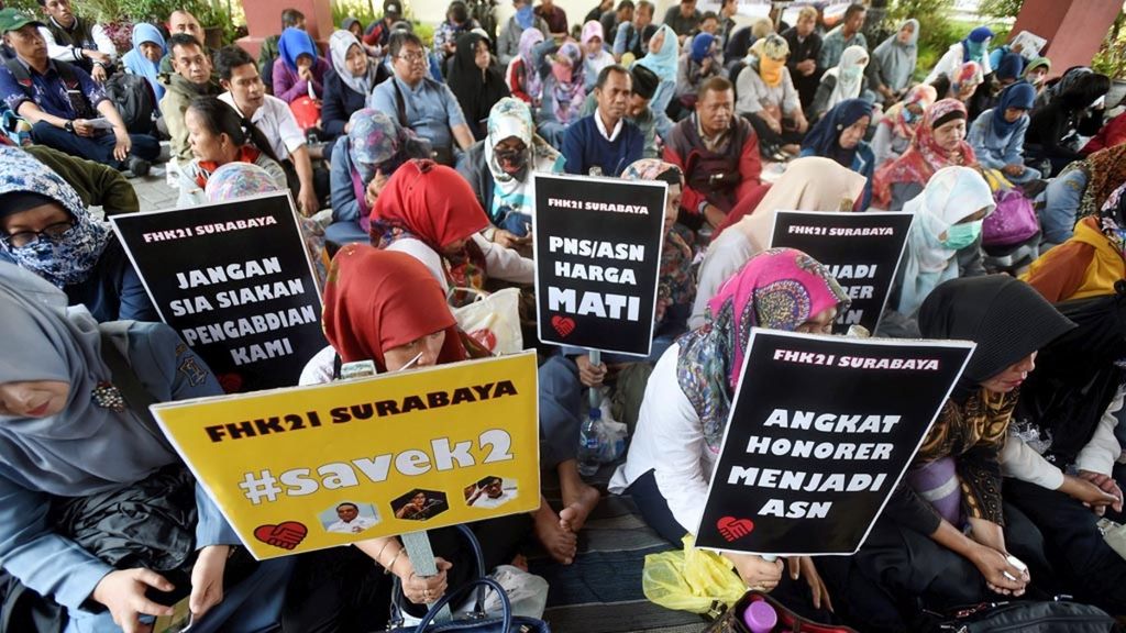 Guru honorer yang tergabung dalam FHK21 Surabaya melakukan aksi damai menolak Peraturan Menteri Pendayagunaan Aparatur Negara dan Reformasi Birokrasi Nomor 36 dan No 37 tahun 2018 di Halaman Gedung DPRD Kota Surabaya, Selasa (18/9/2018).  