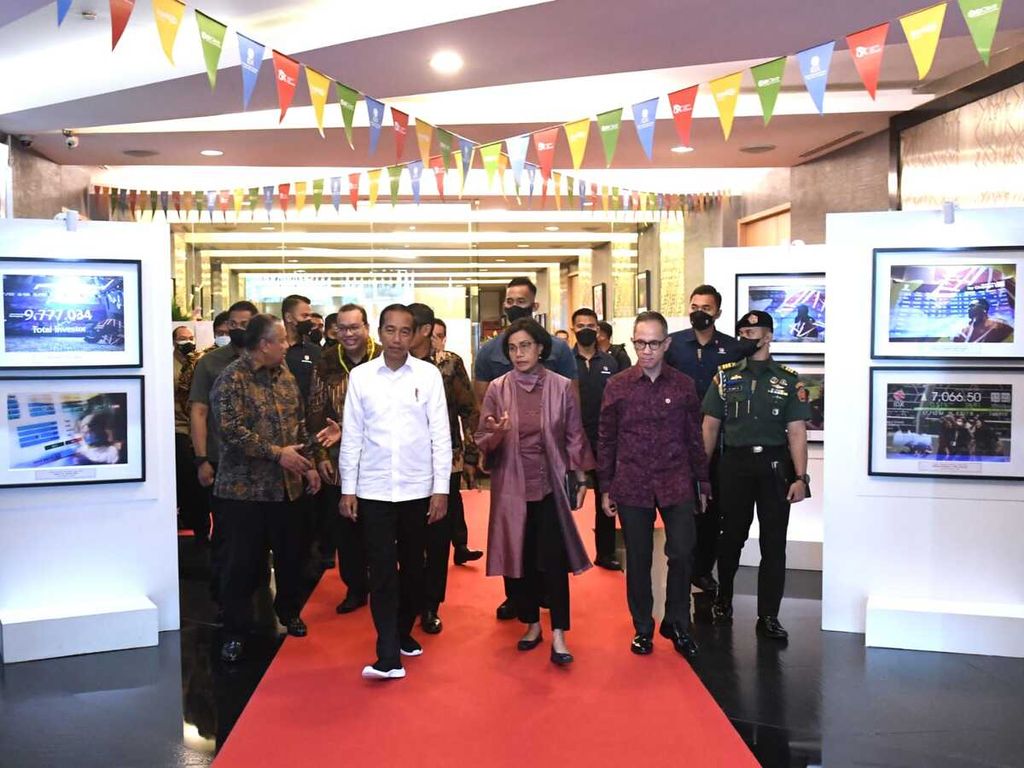 President Joko Widodo along with the Governor of Bank Indonesia Perry Warjiyo (left), Minister of Finance Sri Mulyani Indrawati (third from left), and Chairman of the Financial Services Authority Mahendra Siregar (third from right) pass through a photo exhibition after inaugurating the trading opening of the 2023 Indonesia Stock Exchange, Monday ( 2/1/2023).