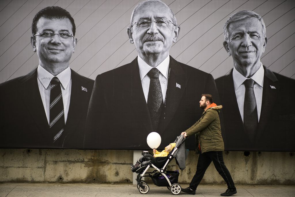 Seorang pria berjalan melewati poster Ketua Partai Rakyat Republik (CHP) dan kandidat presiden dari koalisi Umat, Kemal Kilicdaroglu (tengah), Wali Kota Istanbul Ekrem Imamoglu (kiri), dan Wali Kota Ankara Mansur Yavas di Istanbul, Turki, 6 Mei 2023. 